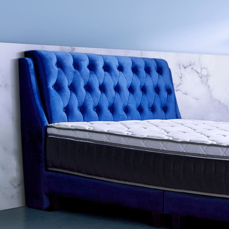 Prime II Series mattress with dark blue bed frame, side view